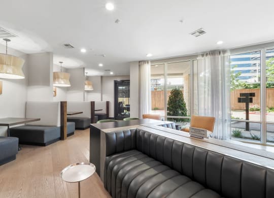 a room with couches and tables in front of a large window