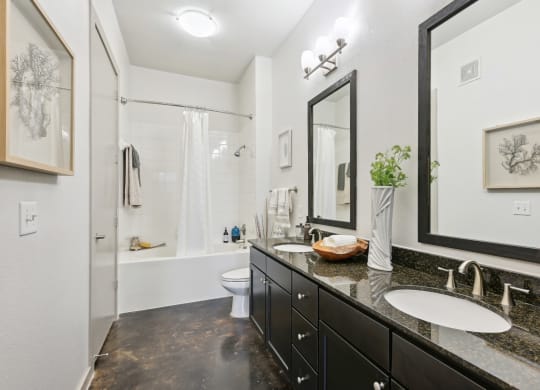Model bathroom with two sinks and a shower at Harlow River Oaks in Houston, TX