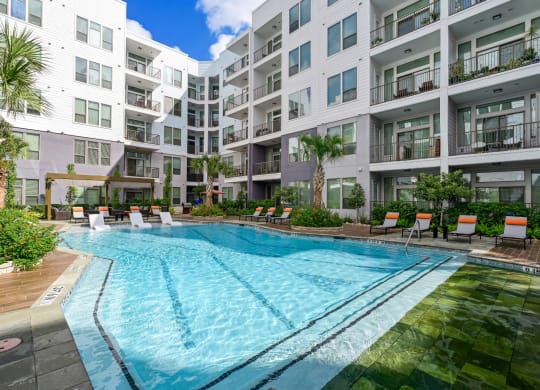 Swimming pool with lounge seating at Harlow River Oaks in Houston, TX