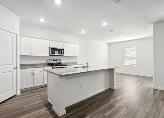 an open kitchen with white cabinets and granit counter top