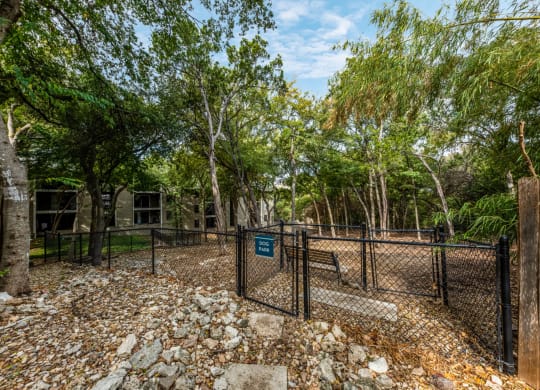 Large woodsy dog park at Hillside Creek Apartments in Austin, TX