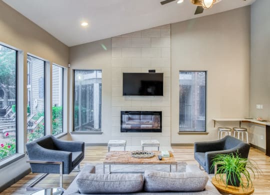 Clubhouse space with fireplace and a couch at Hillside Creek Apartments in Austin, TX