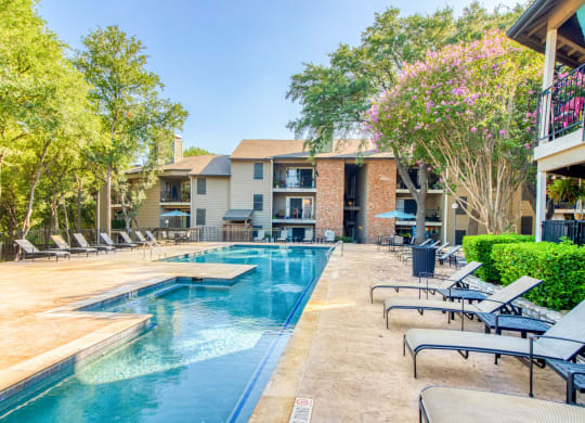 Pool area with lounge chairs at Hillside Creek Apartments in Austin, TX
