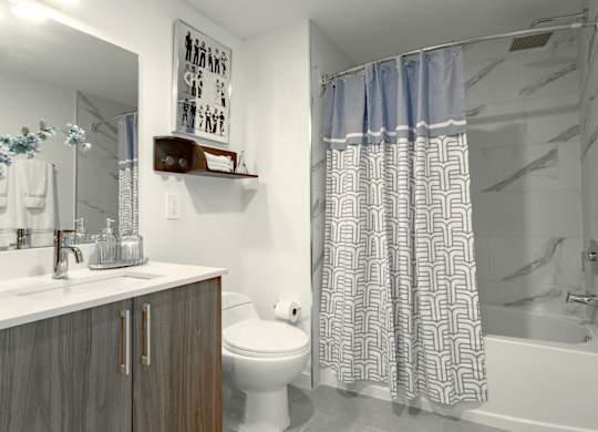 Modern bathroom with a toilet, sink, and shower in our model 2 bedroom apartment at Hollywood Heights on the Boulevard Luxury Apartments in Hollywood, FL
