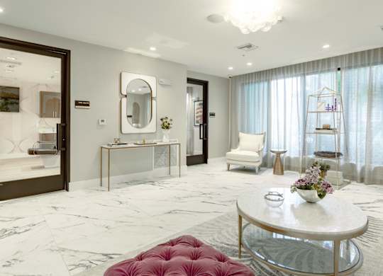 Sitting area outside of the beauty and hair salon with plush couches at Hollywood Heights on the Boulevard Luxury Apartments in Hollywood, FL