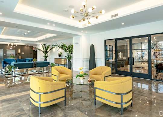 Lobby with two yellow chairs are beside the leasing office and elevators at Hollywood Heights on the Boulevard Luxury Apartments in Hollywood, FL
