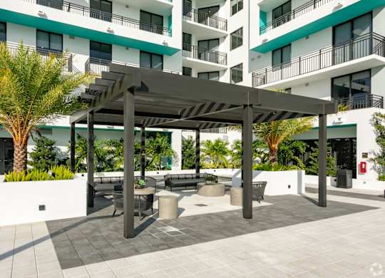 Patio seating under a pergola in our courtyard at Hollywood Heights on the Boulevard Luxury Apartments in Hollywood, FL