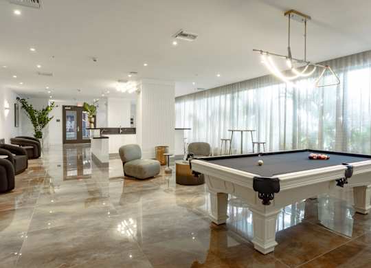 A pool table in our social club with plush seating at Hollywood Heights on the Boulevard Luxury Apartments in Hollywood, FL