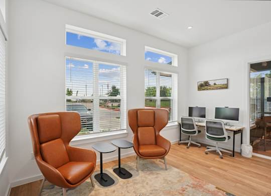 A business center with computers and chairs at Hillside on Parmer Lane Apartments in Austin, TX