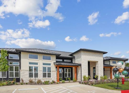 The exterior of a leasing office with parking in front at Hillside on Parmer Lane Apartments in Austin, TX