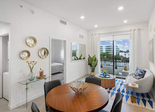 Living room and dining table in our 2-bedroom model with a dining table and chairs  Balcony view of Hollywood Boulevard at Hollywood Heights on the Boulevard Luxury Apartments in Hollywood, FL
