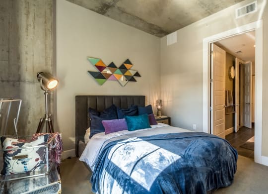 Industrial-inspired bedroom with queen sized bed at The Case Building in Dallas, TX