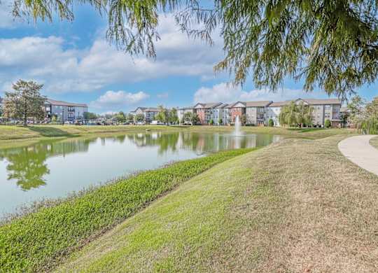 Onsite pond with apartment buildings in the background at Ultris Island Park in Shreveport, LA