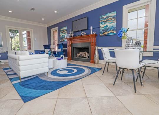 Resident lounge space with a fireplace and a blue rug at Ultris Island Park in Shreveport, LA