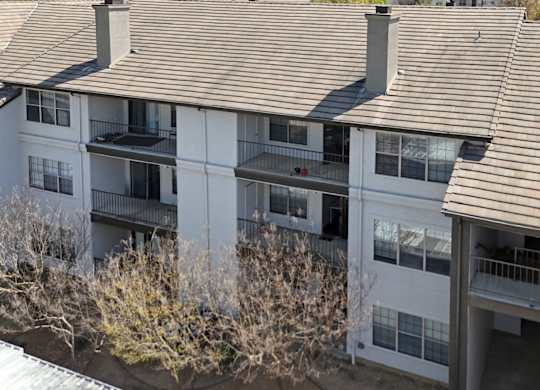 Apartment building with brown shingled roofs and balconies at Jefferson Place Apartments in Irving, TX