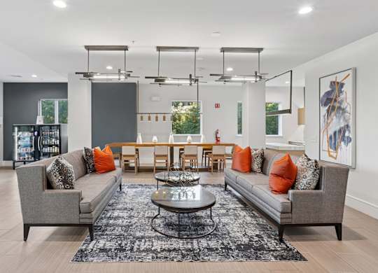 An entertainment lounge with grey sofas, a coffee table, and a gray rug at Knox Heights Apartments in Dallas, TX