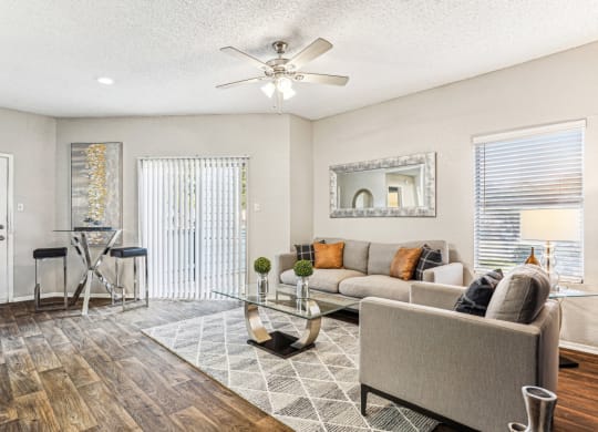 Bright and airy living room with large windows at Laurels of Sendera apartments in Arlington, TX