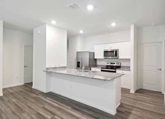 the kitchen with granite countertop and white cabinets