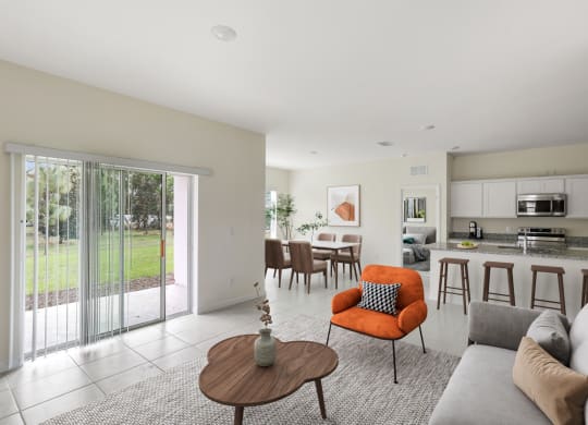 a living room and kitchen with a sliding glass door