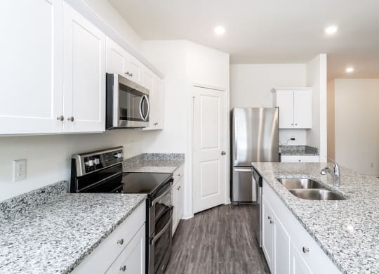 a kitchen with granite countertops and stainless steel appliancesat Beacon at Ashley River Landing, Summerville, SC 29485
