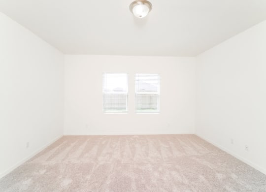 a bedroom with white walls and carpet at Beacon at Bunton Creek, Kyle