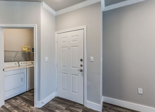 A2 model apartment entrance next to laundry closet at Asheville at Spring Branch apartments in Houston, TX
