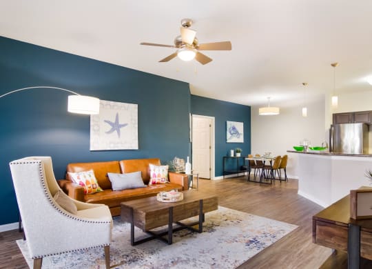 a living room with blue walls and a ceiling fan