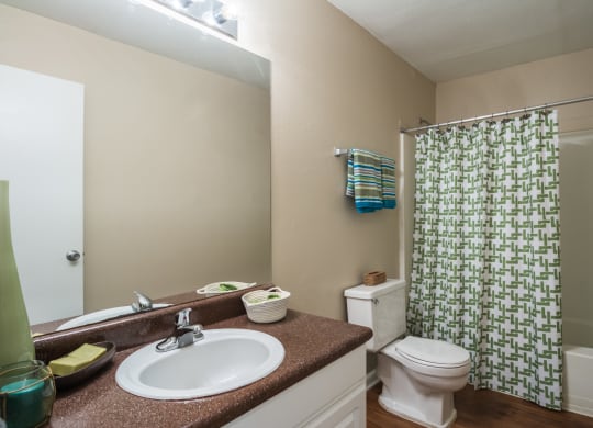 a bathroom with a shower toilet and sink and a mirror at Dunwoody Pointe in Sandy Springs, GA