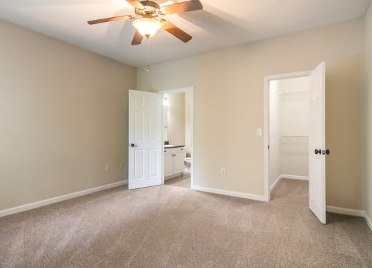 Model bedroom with private bathroom and walk-in closet at Angel Landing Apartment Homes in Pensacola, FL