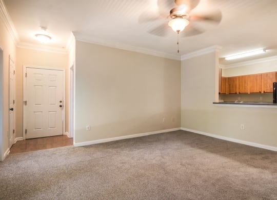 Well-lit living room with plush carpet flooring at Angel Landing apartments in Pensacola, FL