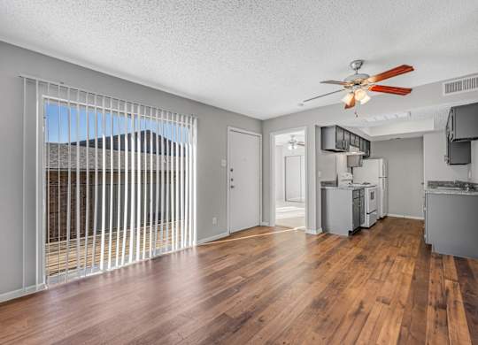 A room with a ceiling fan and wooden floors.