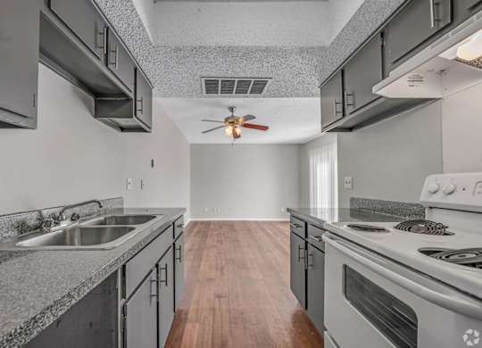 A modern kitchen with a stainless steel sink and stove.