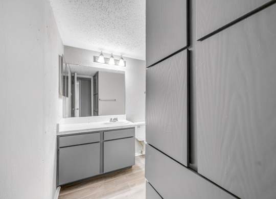 A bathroom with a sink and a mirror.