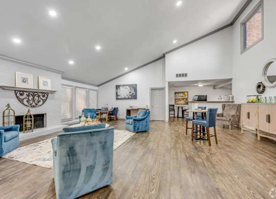A living room with blue chairs and a fireplace.