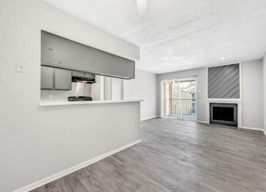 A spacious living room with a fireplace and sliding glass doors.