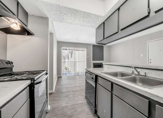 A kitchen with a stove top oven and a sink.