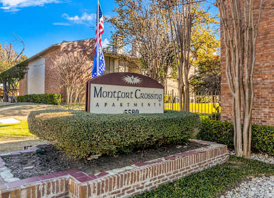 A sign for Montford Crossing apartments stands in front of a building.