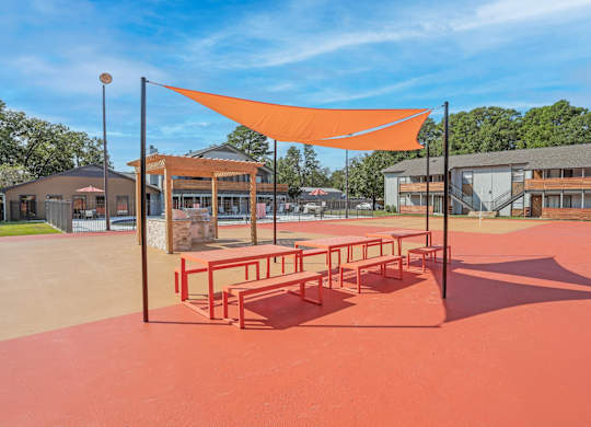 Picnic benches and a communal barbeque in a paved area at The Marq in Shreveport, LA