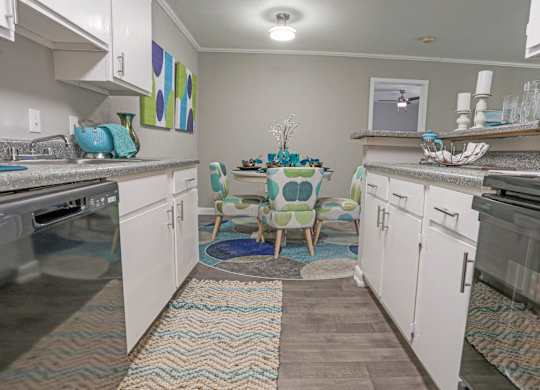 A cypress kitchen with a dining table and chairs in the middle at The Marq in Shreveport, LA