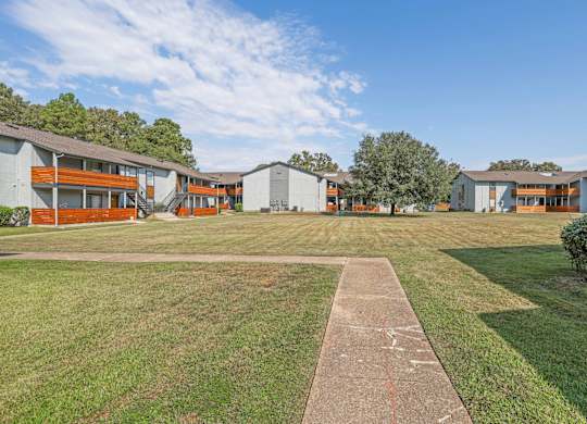 A long concrete walkway leads to a apartment buildings at The Marq apartments in Shreveport, LA