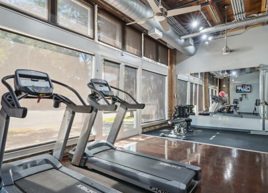 Murray Building gym with cardio equipment, free weights, and multi-use cable machine | Deep Ellum Lofts in Dallas, TX