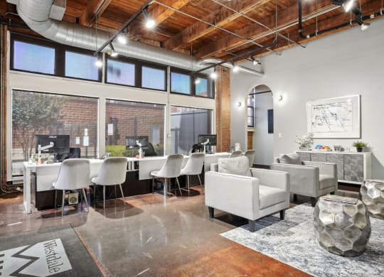 Deep Ellum Lofts Leasing Office with three desks and single seater couches | Deep Ellum Lofts in Dallas, TX