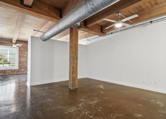 Loft living are with ceiling fan, concrete floors and brick walls | Deep Ellum Lofts in Dallas, TX