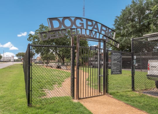 a dog park with a gate and a sign that says dog park
