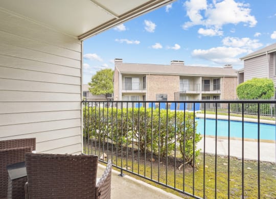 Model A2 floor plan balcony with chairs and view of the pool Noel on The Parkway in Dallas, TX