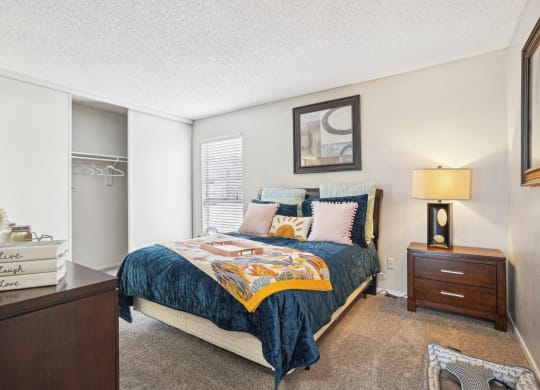 Model A2 floor plan bedroom with a bed, dresser, window Noel on The Parkway in Dallas, TX
