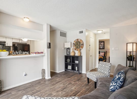 Model A2 floor plan living room with a couch a chair and view of the kitchen Noel on The Parkway in Dallas, TX
