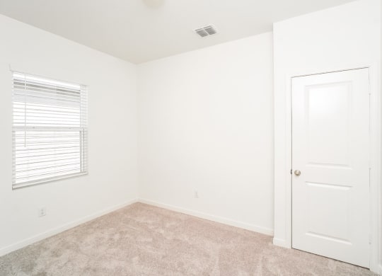 a bedroom with white walls and carpet at Beacon at Meridian, San Antonio
