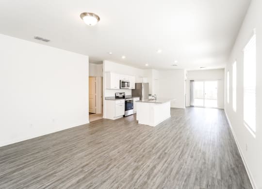 an empty living room with a kitchen in the background at Beacon at Meridian, San Antonio, TX 78245