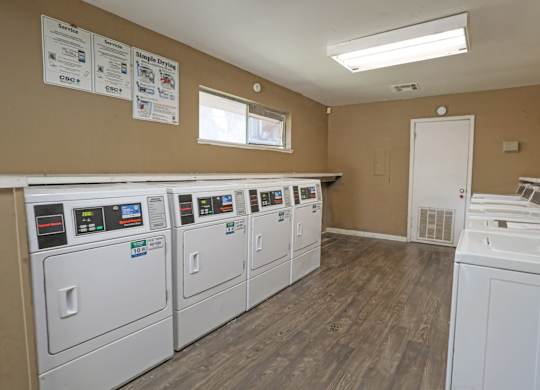 A laundry facility with rows of washers and dryers at Orleans Square in Shreveport, LA